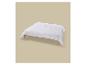 Une couette blanche sur un cadre de lit en bois clair sur fond beige.