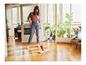 Une femme utilise une Vileda Spray Mop pour nettoyer un sol en bois.