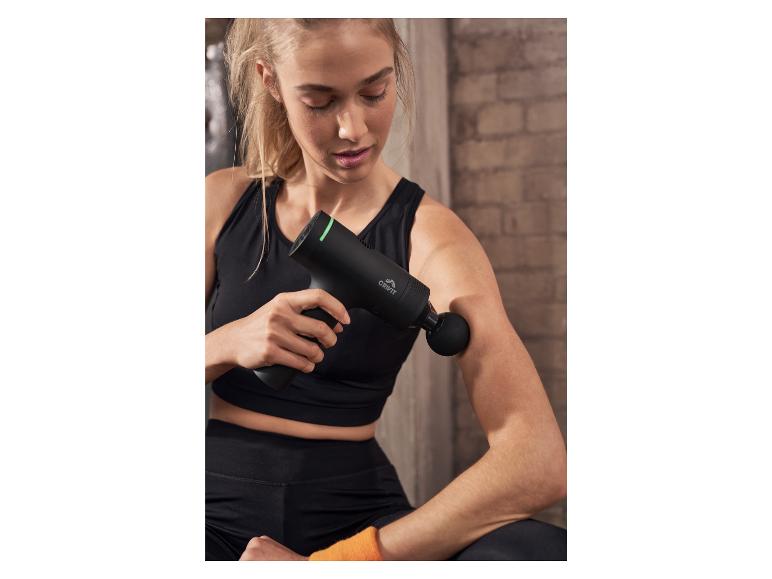 Une femme utilise un pistolet de massage noir de la marque Crivit.