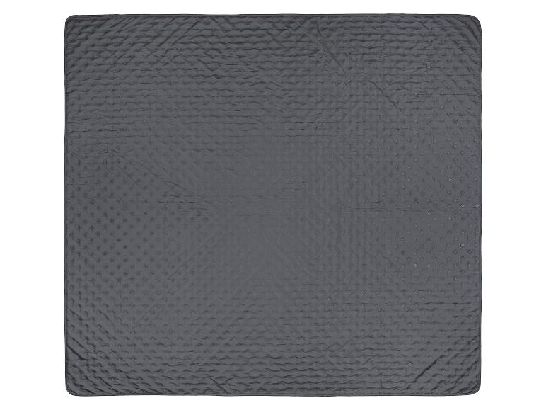 Couverture matelassée grise texturée sur fond blanc.