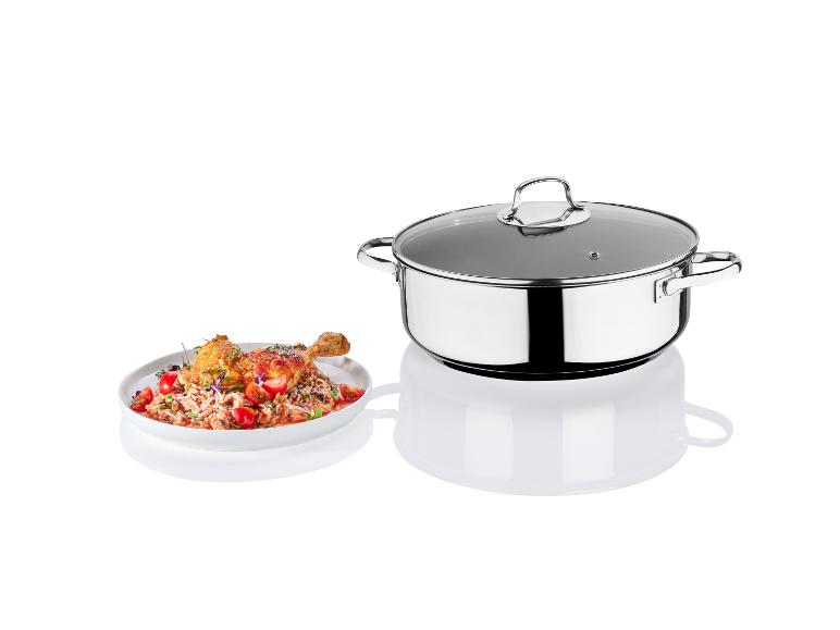 Une casserole en acier inoxydable avec couvercle et une assiette avec du poulet rôti et du riz