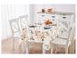 Table avec nappe d'automne et chaises blanches.