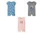 Trois barboteuses pour bébé : une bleue avec Mickey Mouse, une grise avec Stitch et une rose avec Minnie Mouse.