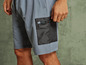 Un homme porte un short bleu avec une poche zippée.