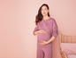 Une femme enceinte dans un ensemble de survêtement rose.
