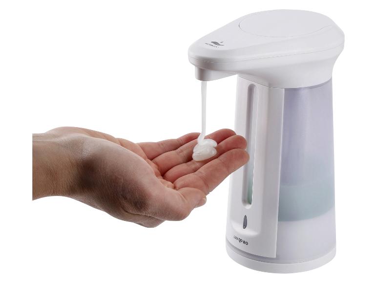 Main recevant du savon d'un distributeur automatique