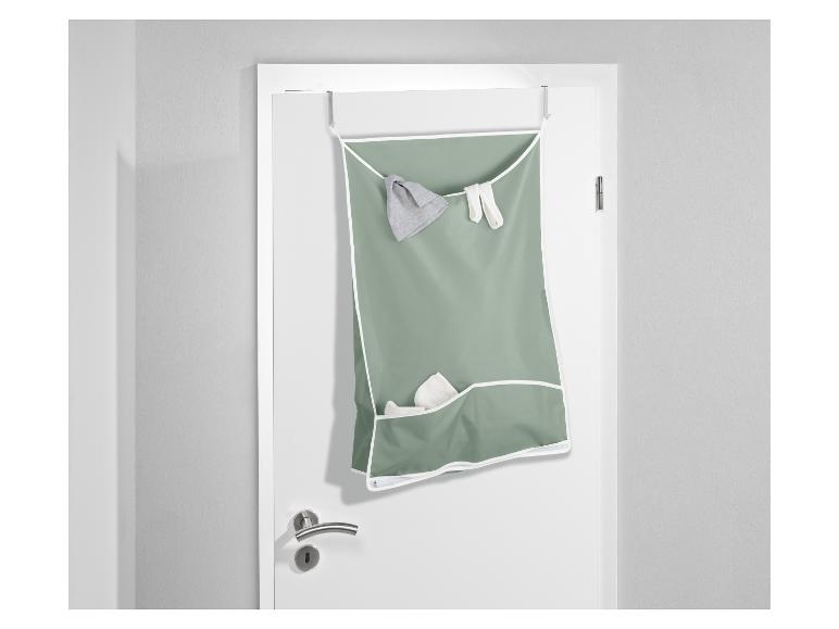 Un sac de rangement vert avec des compartiments suspendu à une porte.