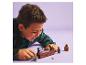 Un garçon joue avec un ensemble LEGO Harry Potter, avec des figurines et un serpent.