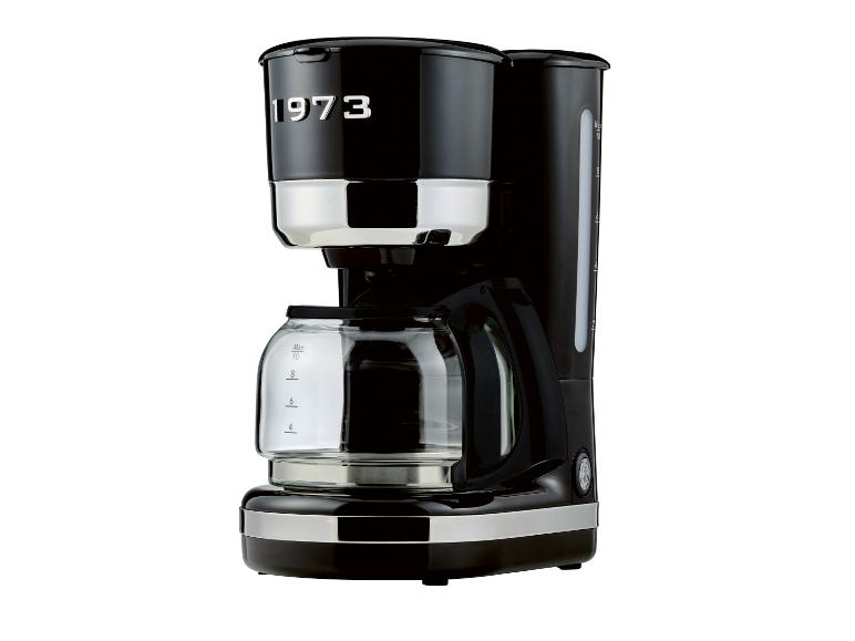 Cafetière noire avec verseuse, affichant le texte '1973' et des accents chromés.