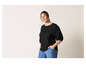 Une femme portant un haut noir et un pantalon bleu.