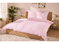 Chambre à coucher avec une parure de lit rayée rose et blanche, des plantes et des cadres.