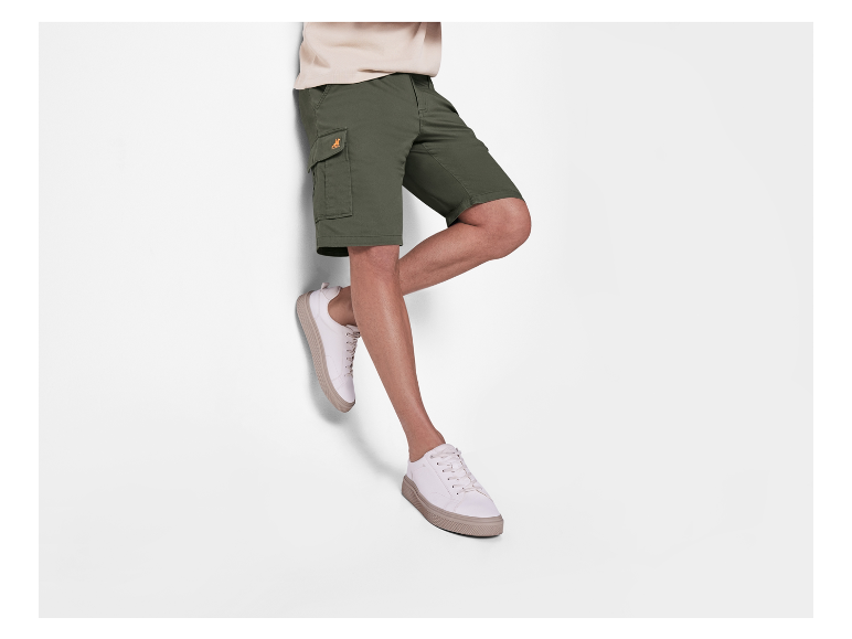 Shorts cargo verts pour homme et baskets blanches.