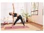 Femme faisant du yoga avec un bloc de yoga et un tapis Domyos.
