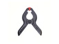 Une pince noire avec un bouton rouge.