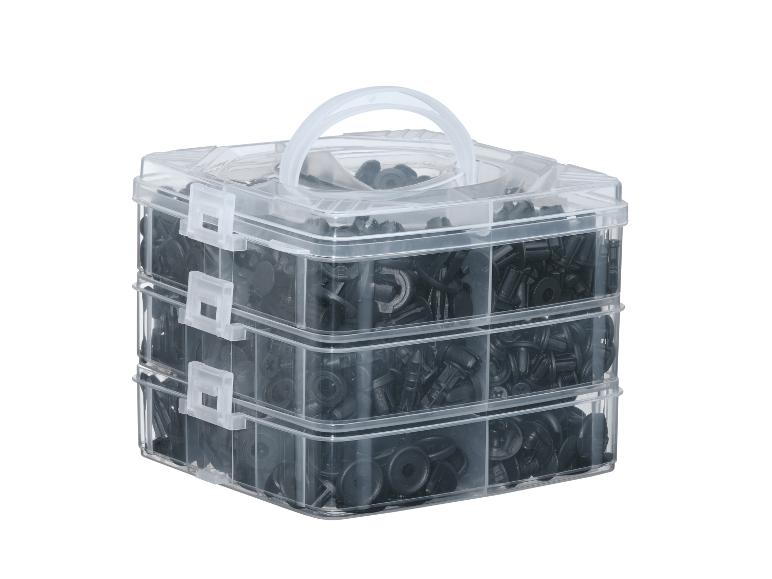 Boîte de rangement transparente à trois niveaux remplie de clips de voiture noirs.