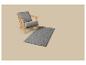 Fauteuil gris avec cadre en bois et un tapis gris à motif géométrique sur fond beige.