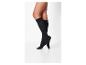 Jambes de femme en chaussettes noires montantes.