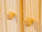 Deux boutons en bois sur une armoire en bois.