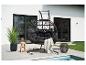 Fauteuil suspendu noir avec coussins sur une terrasse au bord d'une piscine