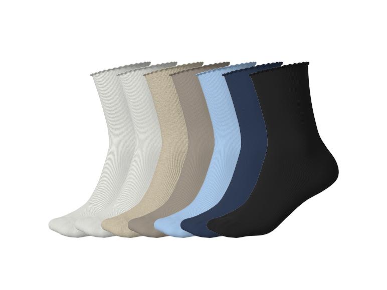 Sept paires de chaussettes côtelées de différentes couleurs : blanc, beige, marron, bleu clair, bleu foncé et noir.
