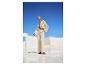 Femme en cardigan ajouré beige et pantalon large, look estival.
