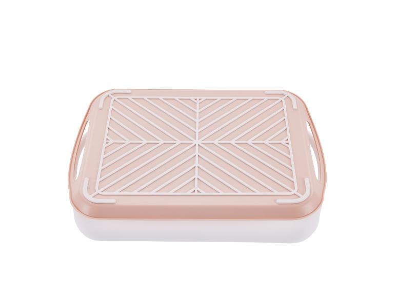 Boîte de rangement rose pâle avec grille intérieure.