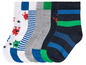 Un ensemble de cinq paires de chaussettes pour garçons avec des motifs de monstres, des rayures et des couleurs unies.