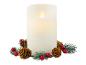Une bougie LED blanche avec effet de flamme entourée de branches de sapin, de pommes de pin et de baies rouges.