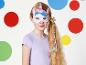 Une fille porte un masque de licorne avec un bandeau arc-en-ciel.