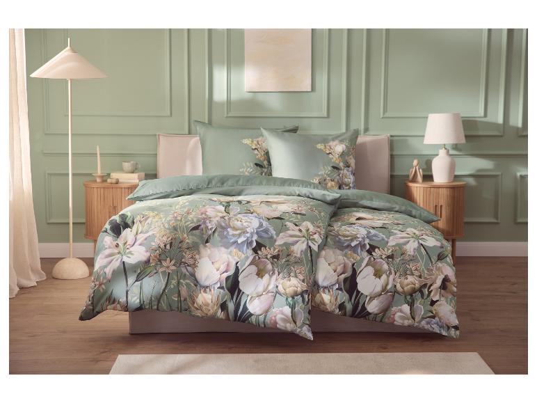 Chambre avec parure de lit florale verte, tables de chevet en bois et lampes.