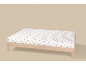 Drap-housse blanc à cœurs rouges sur un lit en bois.