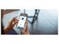 Mains tenant un smartphone affichant une application de nettoyage avec des options de balayage, de lavage et de puissance d'aspiration.