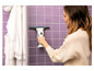 Une femme utilise un nettoyeur de vitres Karcher dans une salle de bain.