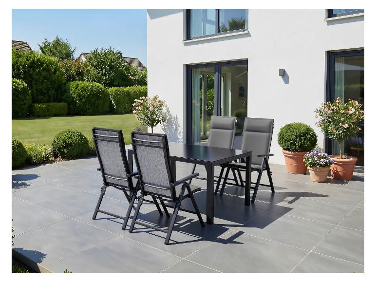 Ensemble de salle à manger d'extérieur avec table noire et quatre chaises grises sur une terrasse.