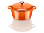 Une cocotte en fonte orange avec un couvercle.