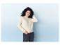 Une femme portant un pull blanc et un pantalon noir.