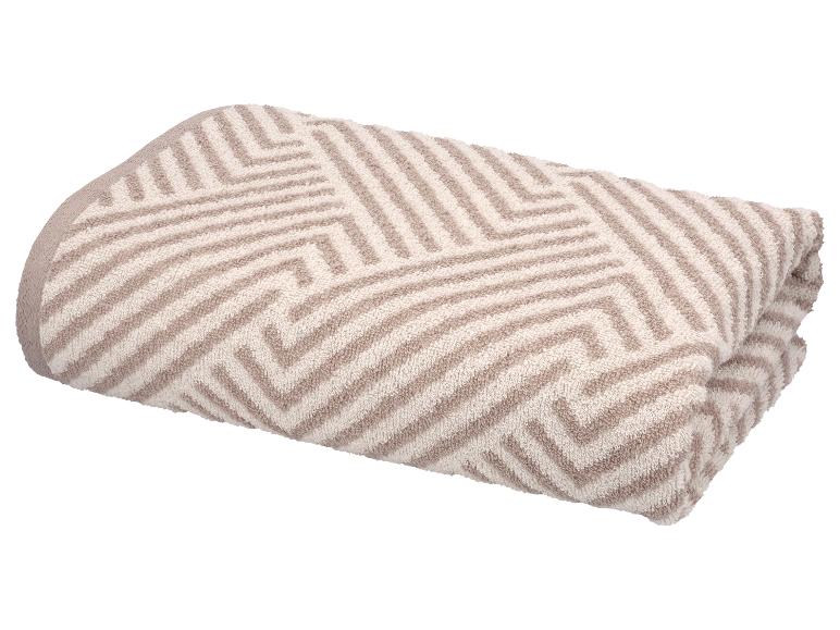 Serviette pliée beige et blanche à motifs