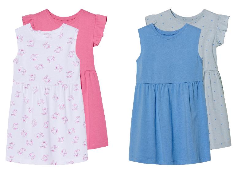 Deux robes pour filles : une à imprimés toucans et une bleue unie.