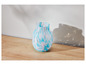 Un vase bleu et blanc avec un motif marbré sur une table en bois.
