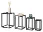 Ensemble de quatre tables d'appoint en métal noir de différentes hauteurs avec objets décoratifs.
