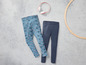 Deux paires de leggings, un avec un imprimé couronne et un uni bleu foncé.