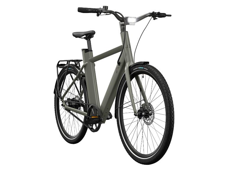Un vélo électrique vert avec transmission par courroie et porte-bagages.