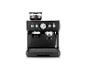 Machine à expresso noire avec moulin intégré, manomètre et grains de café dans la trémie.