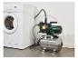 Une machine à laver à côté d'une pompe à eau et d'un réservoir de pression.
