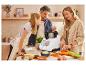 Une famille cuisine ensemble dans la cuisine en utilisant un robot culinaire multifonctionnel.