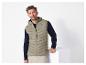 Un homme porte une veste beige Lyle & Scott avec un pull bleu.