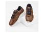 Chaussures de sport marron pour homme sur une surface blanche.