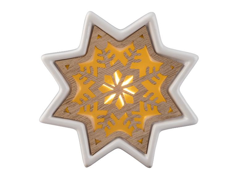 Une décoration de Noël en forme d'étoile blanche et en bois avec un motif de flocon de neige lumineux.