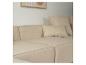 Canapé modulaire beige avec coussins et tableau abstrait au mur.