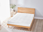 Un matelas blanc sur un cadre de lit en bois